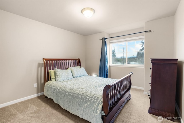 bedroom with light colored carpet and baseboards