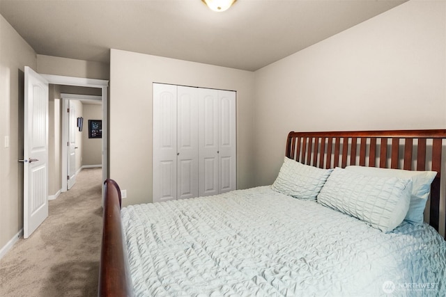 carpeted bedroom with a closet and baseboards