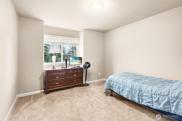 bedroom featuring light carpet and baseboards