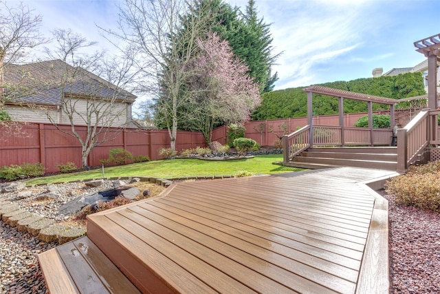 wooden deck featuring a pergola, a fenced backyard, and a lawn