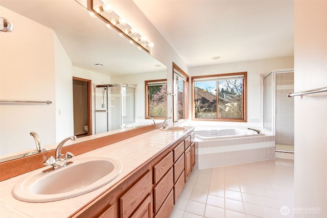 full bath with a sink, a bath, a shower stall, and tile patterned flooring