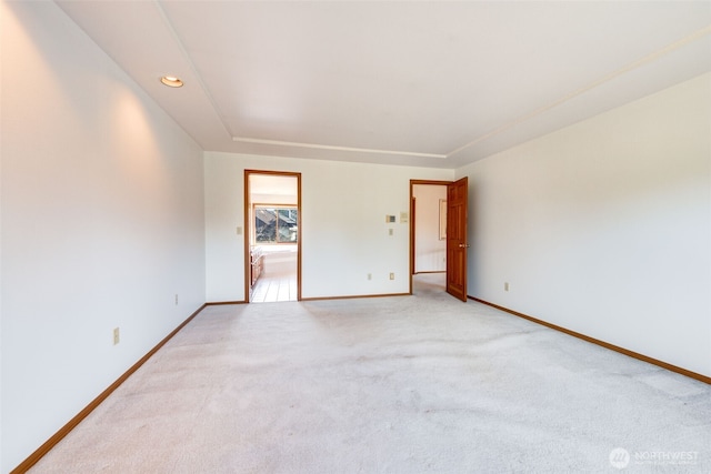 empty room featuring recessed lighting, light colored carpet, and baseboards