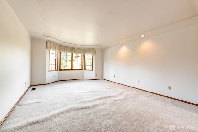 spare room featuring recessed lighting, light colored carpet, visible vents, and baseboards