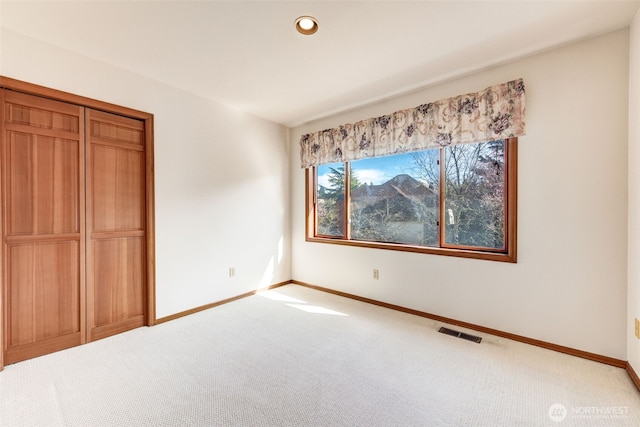 unfurnished bedroom with visible vents, recessed lighting, a closet, baseboards, and light colored carpet