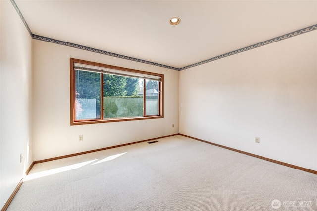 empty room with baseboards, visible vents, and carpet floors