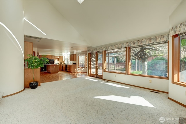 unfurnished living room with light carpet, baseboards, visible vents, and high vaulted ceiling