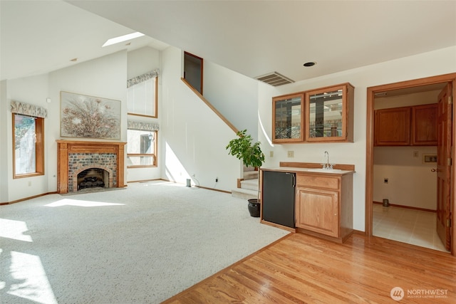 interior space featuring a wealth of natural light, stairway, high vaulted ceiling, and visible vents