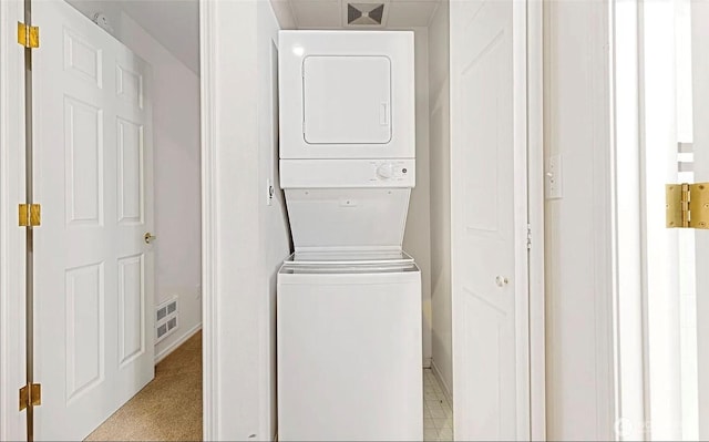 laundry area featuring laundry area, visible vents, and stacked washer / drying machine