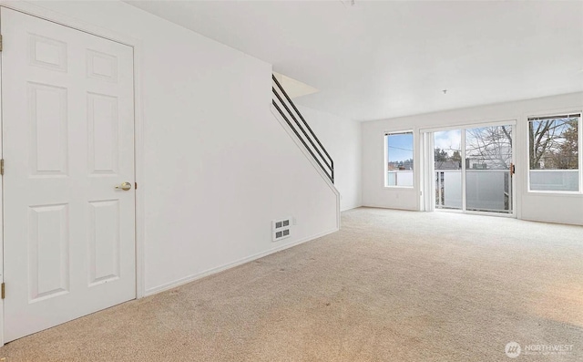 carpeted empty room with visible vents and baseboards