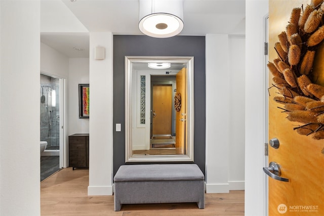 hallway featuring light wood-type flooring and baseboards