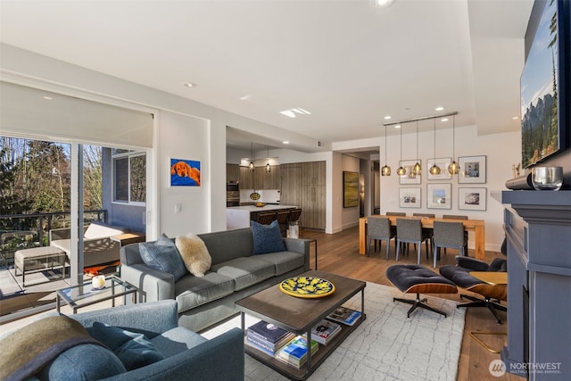 living area with recessed lighting, baseboards, and wood finished floors