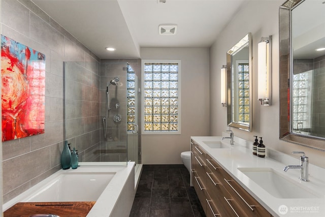 bathroom with a sink, plenty of natural light, toilet, and a shower stall