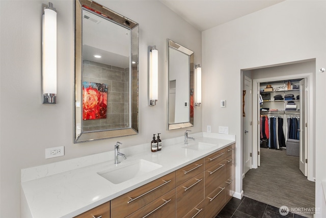 full bathroom featuring double vanity, tile patterned floors, a spacious closet, and a sink