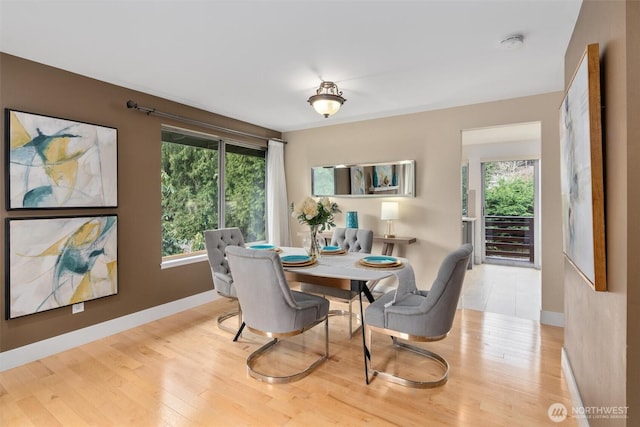 dining area with baseboards and wood finished floors