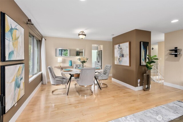 dining area featuring baseboards and light wood-type flooring