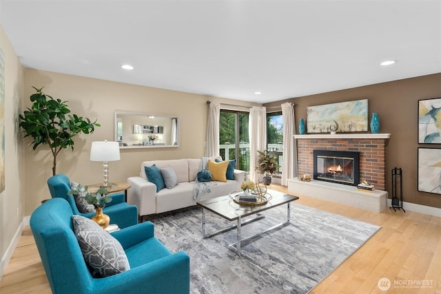 living area with a fireplace, recessed lighting, wood finished floors, and baseboards