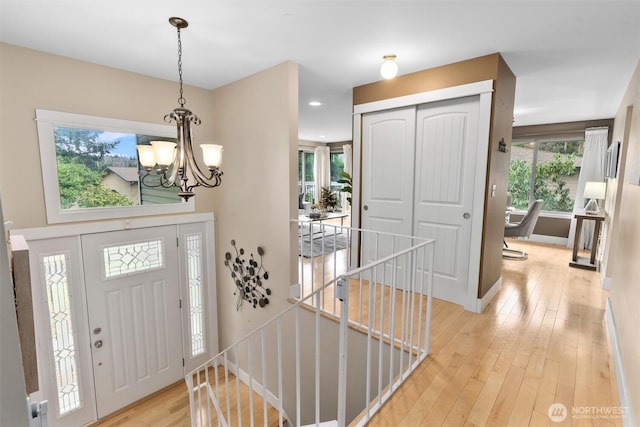 entrance foyer featuring recessed lighting, light wood-type flooring, baseboards, and a notable chandelier