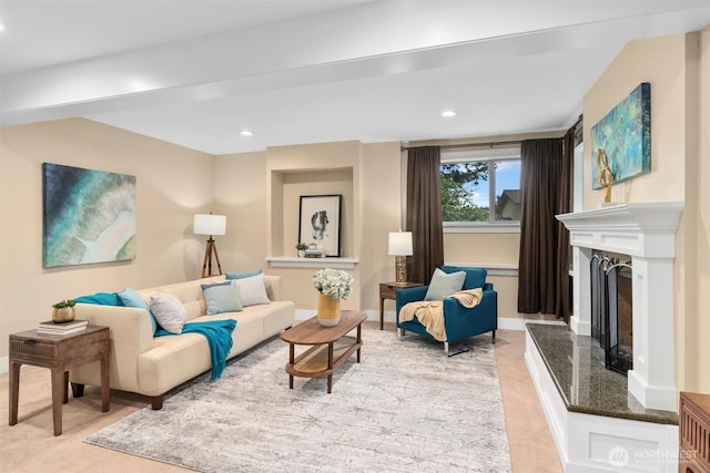 living area with recessed lighting, a fireplace with raised hearth, and baseboards