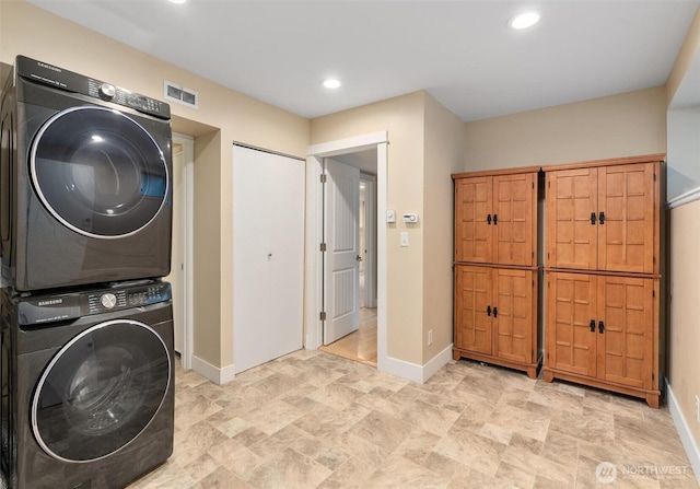 laundry room with visible vents, recessed lighting, stacked washer / drying machine, baseboards, and laundry area