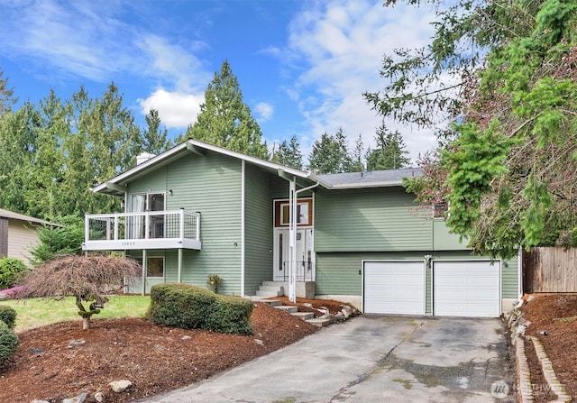 view of front of house with a garage, a balcony, and concrete driveway