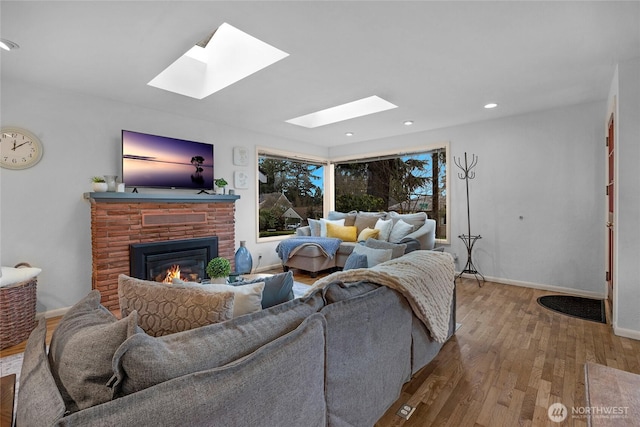 living area with a fireplace, baseboards, wood finished floors, and recessed lighting