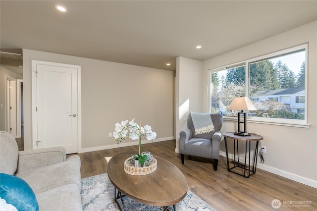 living area with baseboards, wood finished floors, and recessed lighting