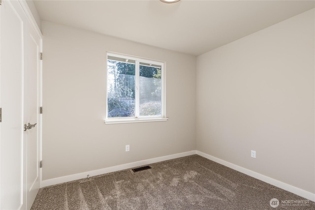 carpeted spare room featuring visible vents and baseboards