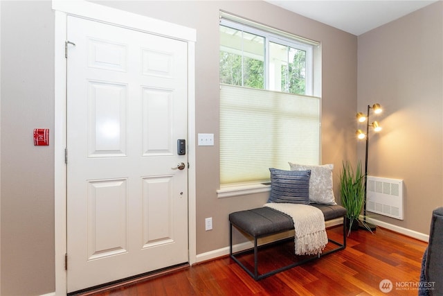 interior space with a wall unit AC, wood finished floors, and baseboards