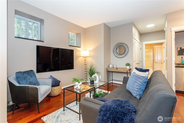 living area featuring baseboards and wood finished floors