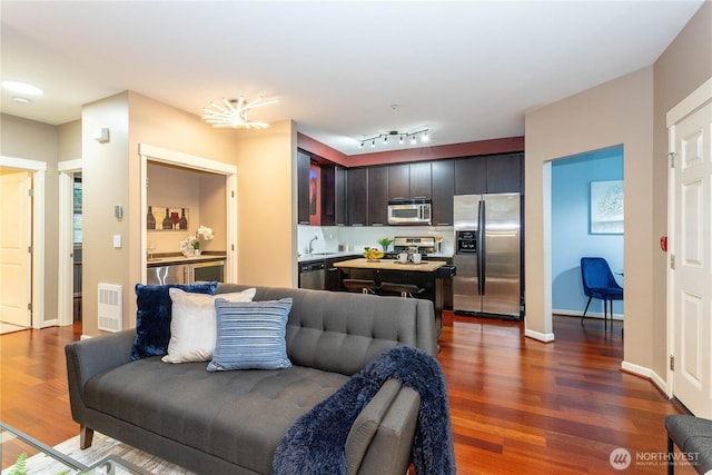 living room featuring baseboards, visible vents, and dark wood-type flooring