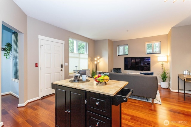 kitchen with a kitchen island, baseboards, and wood finished floors