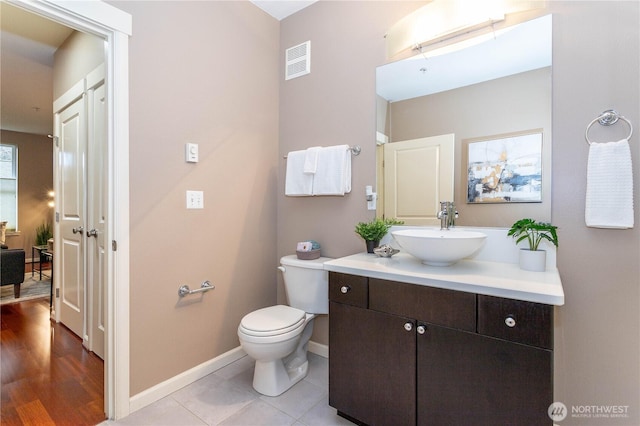 bathroom with toilet, vanity, visible vents, baseboards, and tile patterned floors