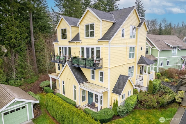 exterior space featuring a shingled roof and a balcony