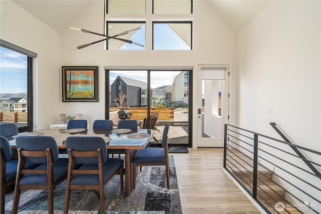 dining area featuring high vaulted ceiling, a wealth of natural light, and light wood-style floors