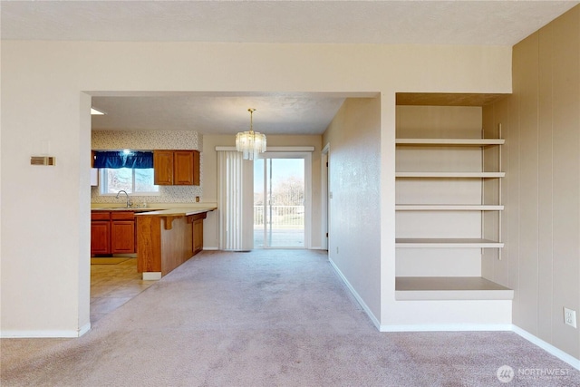 515 SE 5th St, College Place, WA 99324 - kitchen with a kitchen breakfast bar, brown cabinetry, a sink, and light colored carpet