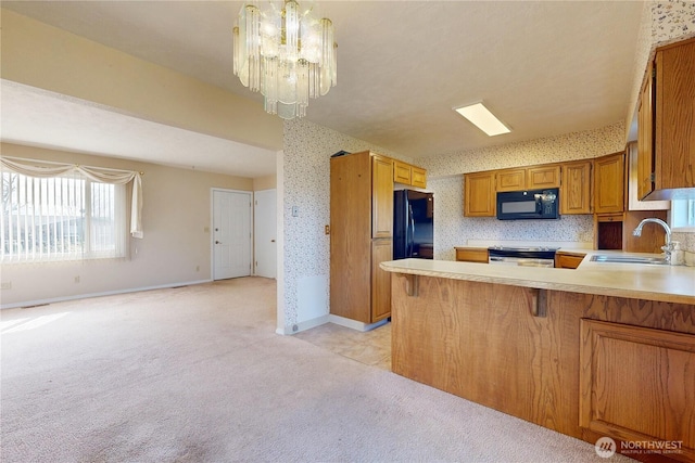 515 SE 5th St, College Place, WA 99324 - kitchen featuring wallpapered walls, light colored carpet, light countertops, black appliances, and a sink