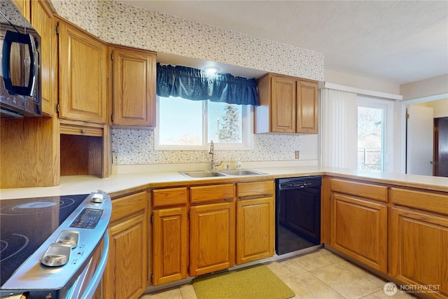 515 SE 5th St, College Place, WA 99324 - kitchen featuring light tile patterned floors, light countertops, brown cabinetry, a sink, and black appliances
