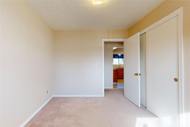 515 SE 5th St, College Place, WA 99324 - unfurnished bedroom with a closet, light colored carpet, a textured ceiling, and baseboards