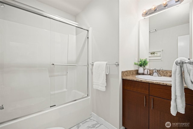 bathroom featuring marble finish floor, enclosed tub / shower combo, vanity, and baseboards