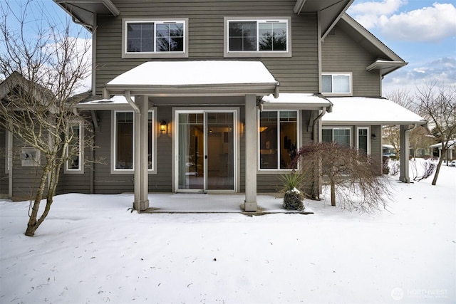 view of snow covered back of property