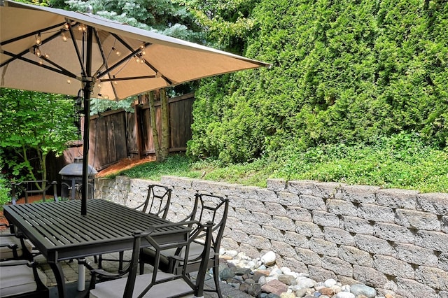 view of patio featuring outdoor dining area, fence, and area for grilling