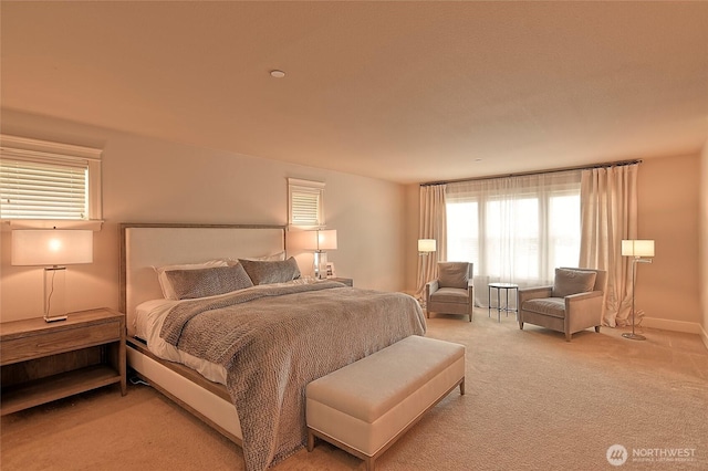 bedroom featuring baseboards and light colored carpet