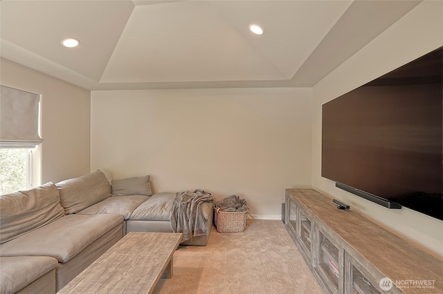 carpeted living room featuring baseboards, a raised ceiling, and recessed lighting