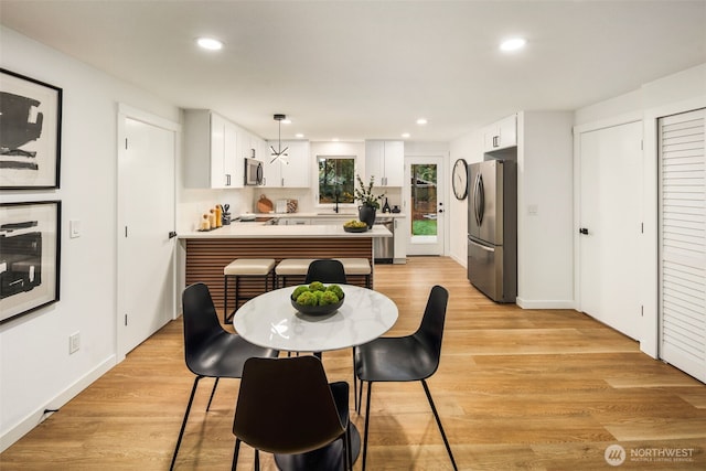 dining area with recessed lighting, baseboards, and light wood finished floors