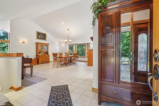 entryway with baseboards, vaulted ceiling, an inviting chandelier, and light tile patterned floors