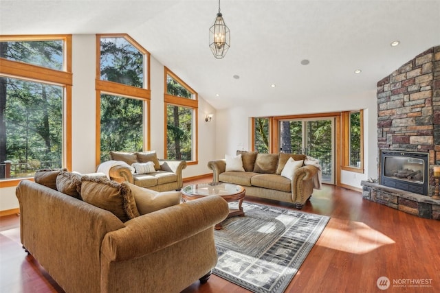 living area featuring baseboards, wood finished floors, a fireplace, high vaulted ceiling, and recessed lighting