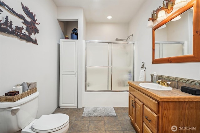 bathroom featuring toilet, recessed lighting, enclosed tub / shower combo, and vanity