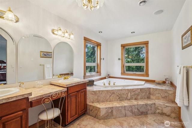 full bathroom featuring a garden tub, double vanity, and a sink