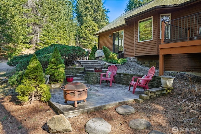 view of patio featuring stairs and an outdoor fire pit