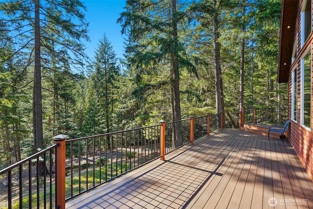 wooden terrace featuring a view of trees